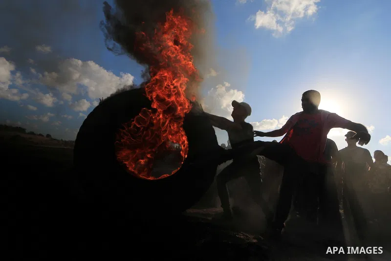 Palestinian protesters gather during clashes with Israeli troops in tents protest where Palestinians demand the right to return to their homeland at the Israel-Gaza border, in Al-Bureij in the center of Gaza Strip on Sep...