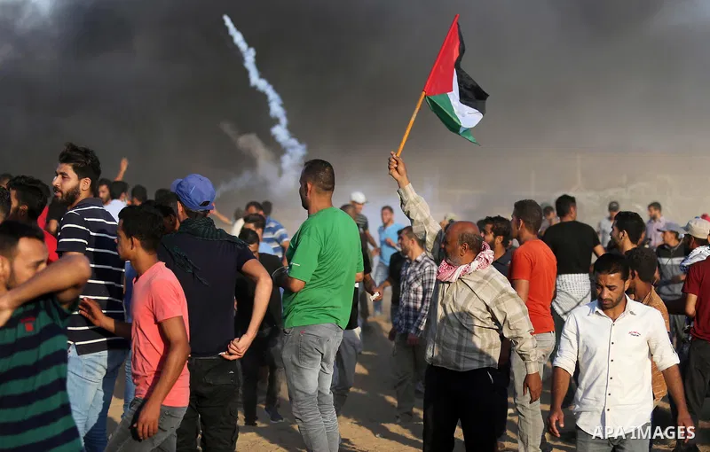 Palestinian protesters gather during clashes with Israeli troops in tents protest where Palestinians demand the right to return to their homeland at the Israel-Gaza border, in Khan Younis in the southern Gaza Strip on Se...