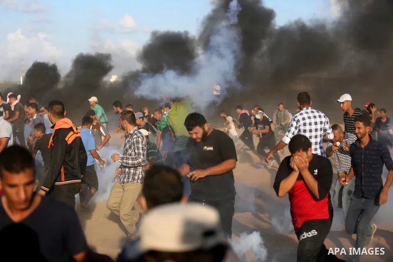 Palestinian protesters gather during clashes with Israeli troops in tents protest where Palestinians demand the right to return to their homeland at the Israel-Gaza border, in Khan Younis in the southern Gaza Strip on Se...