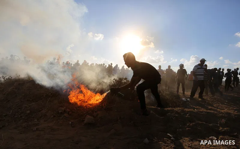 Palestinian protesters gather during clashes with Israeli troops in tents protest where Palestinians demand the right to return to their homeland at the Israel-Gaza border, in Khan Younis in the southern Gaza Strip on Se...