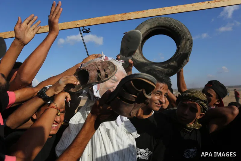 Palestinian protesters hang a doll wearing a mask depicting US President Donald Trump's face during clashes with Israeli troops in tents protest where Palestinians demand the right to return to their homeland at the Isra...