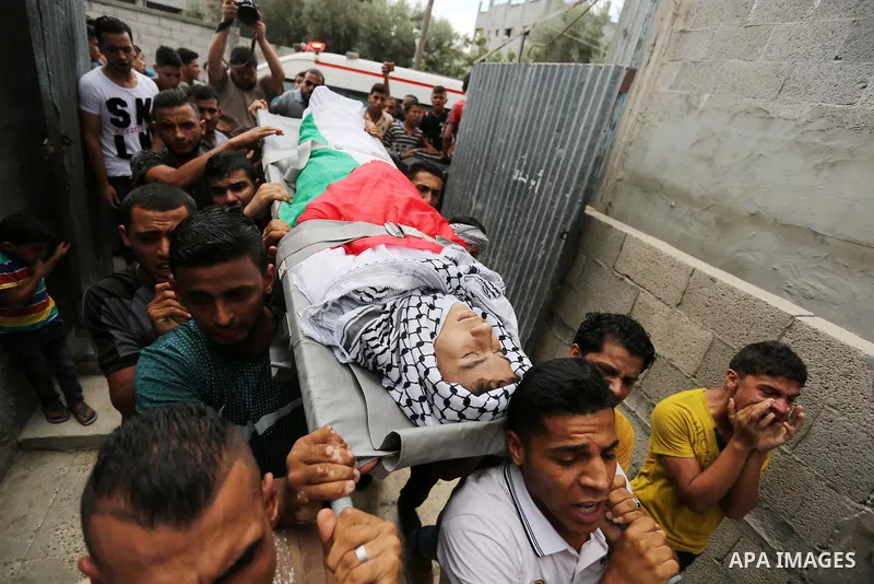 Mourners carry the body of Palestinian Belal Khafaja, 17, who was shot dead by Israeli troops during clashes in tents protest at the Israel-Gaza border, during his funeral in Rafah in the southern Gaza Strip on September...
