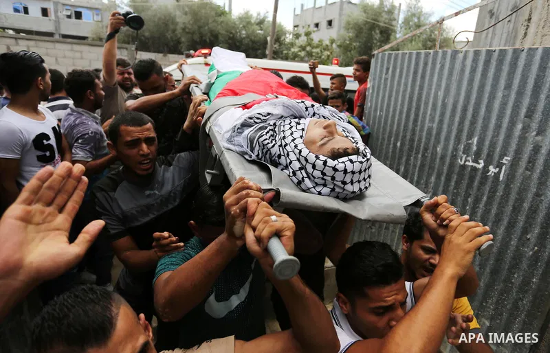Mourners carry the body of Palestinian Belal Khafaja, 17, who was shot dead by Israeli troops during clashes in tents protest at the Israel-Gaza border, during his funeral in Rafah in the southern Gaza Strip on September...