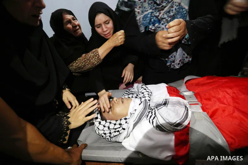 Relatives of Palestinian Belal Khafaja, 17, who was shot dead by Israeli troops during clashes in tents protest at the Israel-Gaza border, mourn next to his body during his funeral in Rafah in the southern Gaza Strip on...