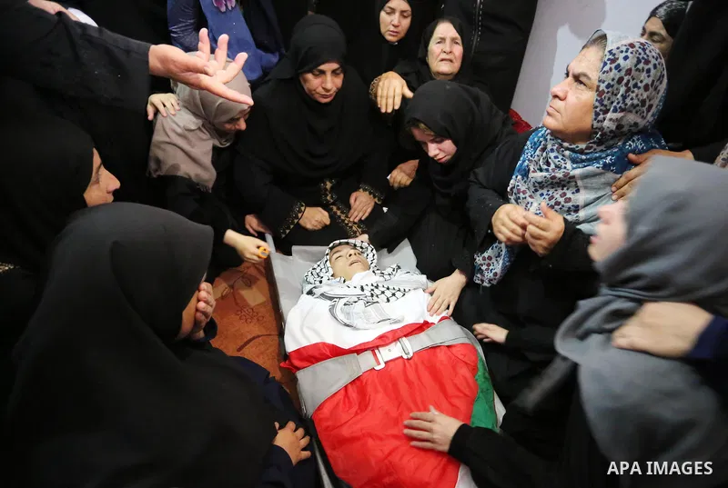 Relatives of Palestinian Belal Khafaja, 17, who was shot dead by Israeli troops during clashes in tents protest at the Israel-Gaza border, mourn next to his body during his funeral in Rafah in the southern Gaza Strip on...