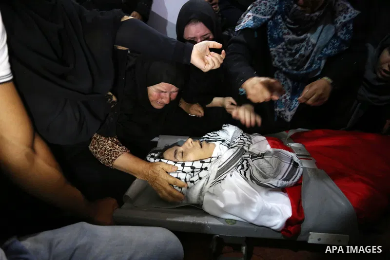 Relatives of Palestinian Belal Khafaja, 17, who was shot dead by Israeli troops during clashes in tents protest at the Israel-Gaza border, mourn next to his body during his funeral in Rafah in the southern Gaza Strip on...