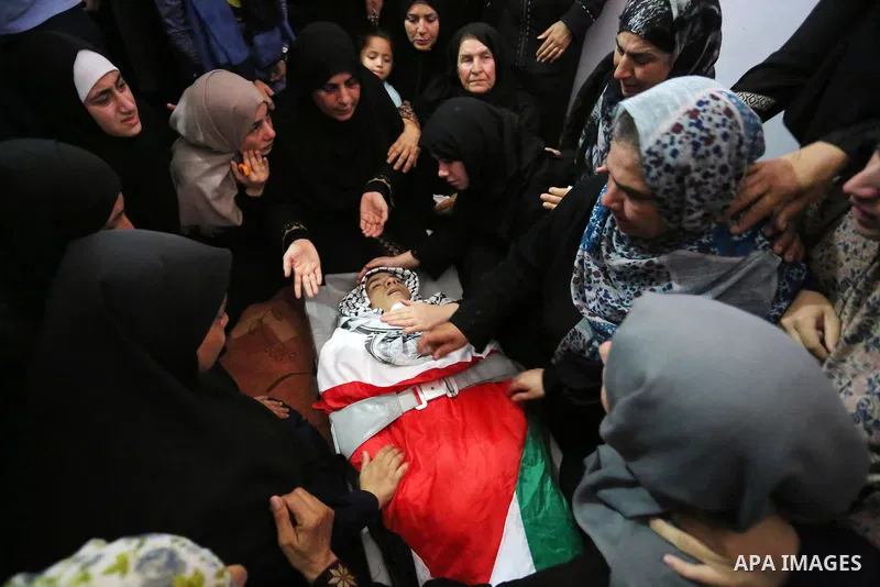 Relatives of Palestinian Belal Khafaja, 17, who was shot dead by Israeli troops during clashes in tents protest at the Israel-Gaza border, mourn next to his body during his funeral in Rafah in the southern Gaza Strip on...