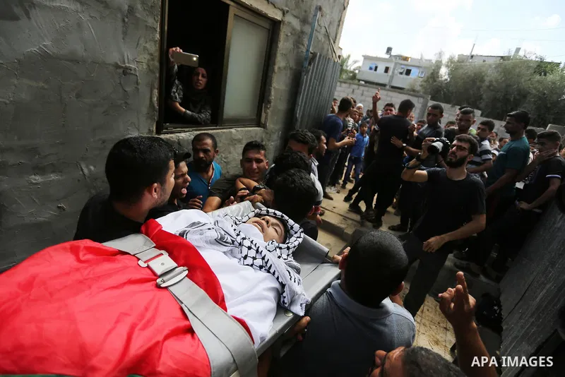Mourners carry the body of Palestinian Belal Khafaja, 17, who was shot dead by Israeli troops during clashes in tents protest at the Israel-Gaza border, during his funeral in Rafah in the southern Gaza Strip on September...