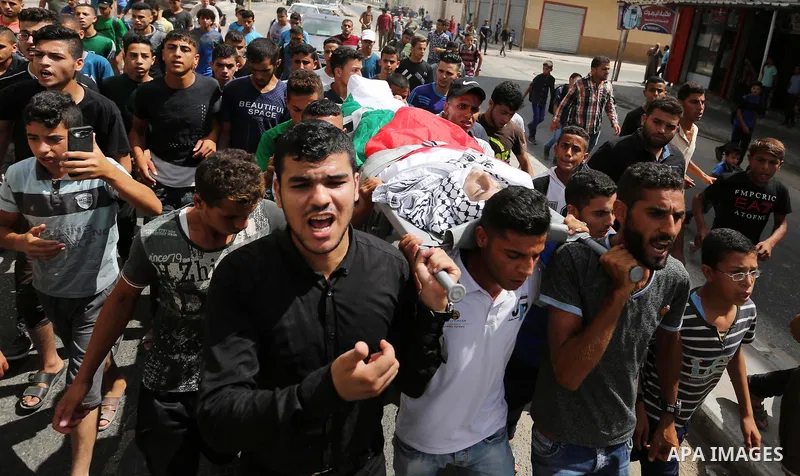 Mourners carry the body of Palestinian Belal Khafaja, 17, who was shot dead by Israeli troops during clashes in tents protest at the Israel-Gaza border, during his funeral in Rafah in the southern Gaza Strip on September...