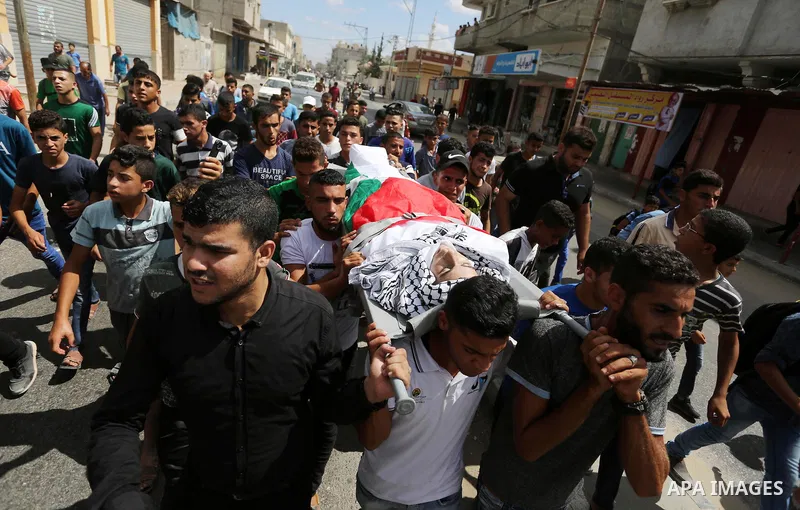 Mourners carry the body of Palestinian Belal Khafaja, 17, who was shot dead by Israeli troops during clashes in tents protest at the Israel-Gaza border, during his funeral in Rafah in the southern Gaza Strip on September...