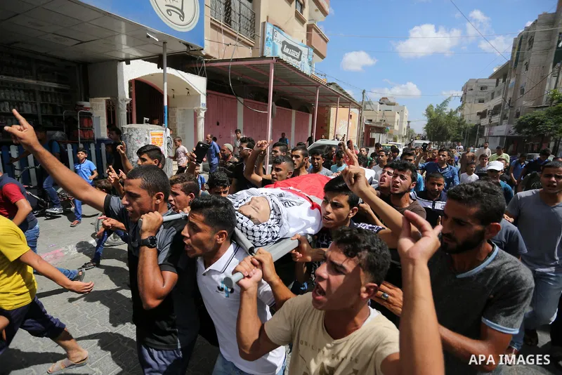 Mourners carry the body of Palestinian Belal Khafaja, 17, who was shot dead by Israeli troops during clashes in tents protest at the Israel-Gaza border, during his funeral in Rafah in the southern Gaza Strip on September...