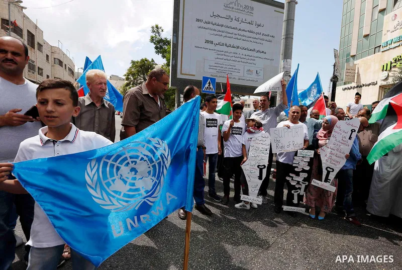 Palestinians take part during a protest against the United States decision to stop funding and backing the United Nations Relief and Works Agency (UNRWA) in the West Bank city of Hebron on September 8, 2018. The United S...