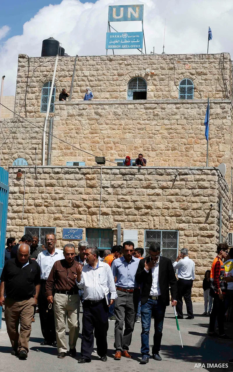 Palestinians take part during a protest against the United States decision to stop funding and backing the United Nations Relief and Works Agency (UNRWA) in the West Bank city of Hebron on September 8, 2018. The United S...