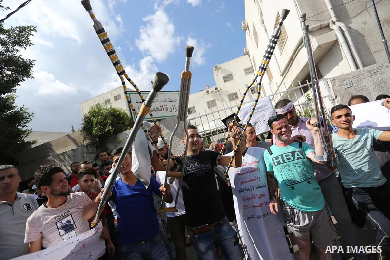Palestinian graduates hold placards during a protest to demand their rights, outside the Ministry of Labor headquarters in Gaza city on September 9, 2018. Photo by Ashraf Amra
