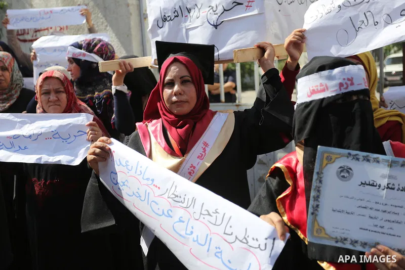 Palestinian graduates hold placards during a protest to demand their rights, outside the Ministry of Labor headquarters in Gaza city on September 9, 2018. Photo by Ashraf Amra