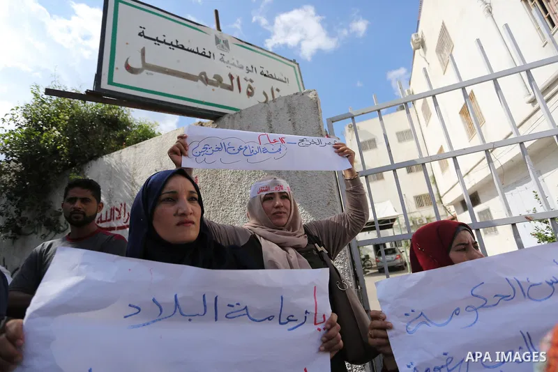 Palestinian graduates hold placards during a protest to demand their rights, outside the Ministry of Labor headquarters in Gaza city on September 9, 2018. Photo by Ashraf Amra