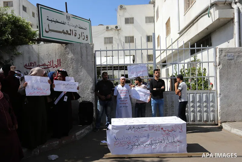 Palestinian graduates hold placards during a protest to demand their rights, outside the Ministry of Labor headquarters in Gaza city on September 9, 2018. Photo by Ashraf Amra