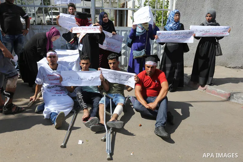 Palestinian graduates hold placards during a protest to demand their rights, outside the Ministry of Labor headquarters in Gaza city on September 9, 2018. Photo by Ashraf Amra