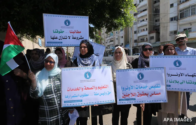 Palestinians take part during a protest against the United States decision to stop funding and backing the United Nations agency for Palestinian refugees (UNRWA) outside its headquarter office, in Gaza city on September...