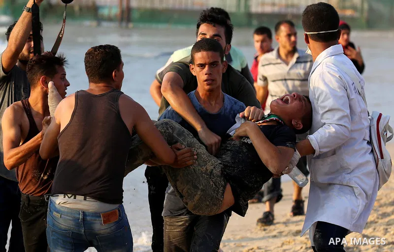 A wounded Palestinian protester is evacuated during a demonstration against the Israeli blockade on Gaza Strip, along the Gaza sea barrier on the maritime border with Israel near Kibbutz Zikim, north of Beit Lahia in the...