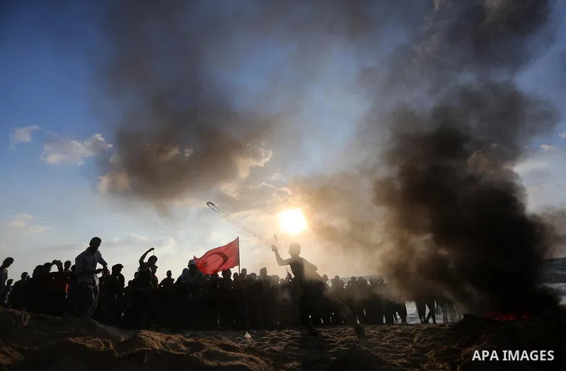 A Palestinian protester uses a slingshot to hurl stones towards Israeli troops during a demonstration against the Israeli blockade on Gaza Strip, along the Gaza sea barrier on the maritime border with Israel near Kibbutz...