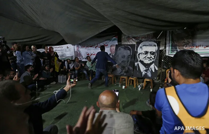 A Palestinian artist Mohammed al Diri, draws the portrait of Palestinian president Mahmoud Abbas and the the president Paraguay Mario Abdo Benitez, during a protest at tents in the West Bank village of Khan Al-Ahmar near...