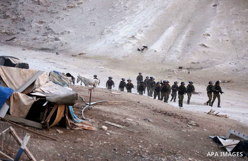 Israeli forces walk after removing shacks which were erected by Palestinian activists to protest against Israel's plan to demolish the Palestinian Bedouin village of Khan al-Ahmar in the occupied West Bank September 13,...
