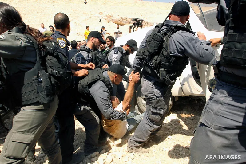 Israeli troops detain a Palestinian protester during a demonstration against the blocking of the road leading to the Palestinian Bedouin village of Khan al-Ahmar in the occupied West Bank on September 14, 2018. Photo by...