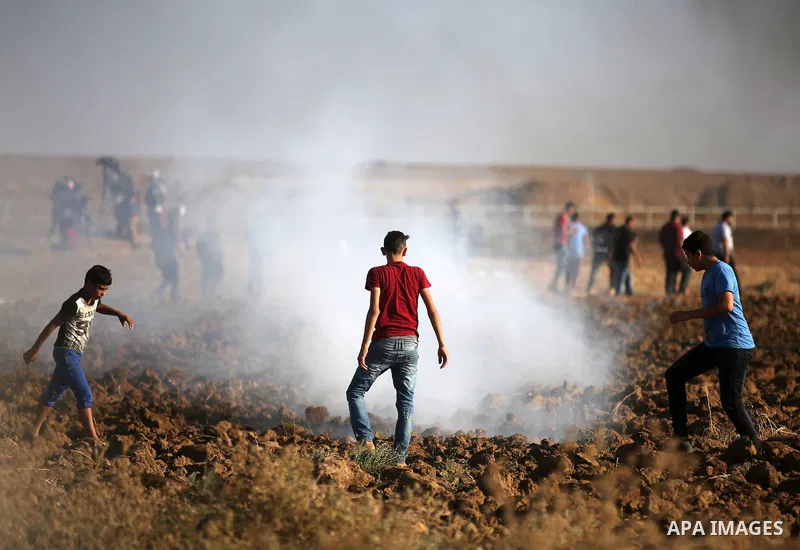 Palestinian protesters gather during clashes with Israeli troops in tents protest where Palestinians demand the right to return to their homeland at the Israel-Gaza border, in east of Gaza city on September 14, 2018. Pho...