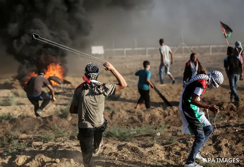Palestinian protesters gather during clashes with Israeli troops in tents protest where Palestinians demand the right to return to their homeland at the Israel-Gaza border, in east of Gaza city on September 14, 2018. Pho...