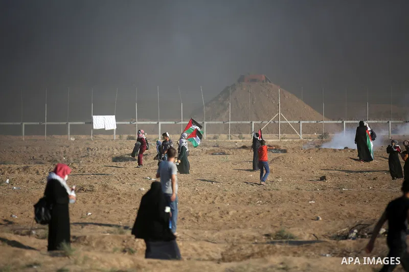 Palestinian protesters gather during clashes with Israeli troops in tents protest where Palestinians demand the right to return to their homeland at the Israel-Gaza border, in east of Gaza city on September 14, 2018. Pho...