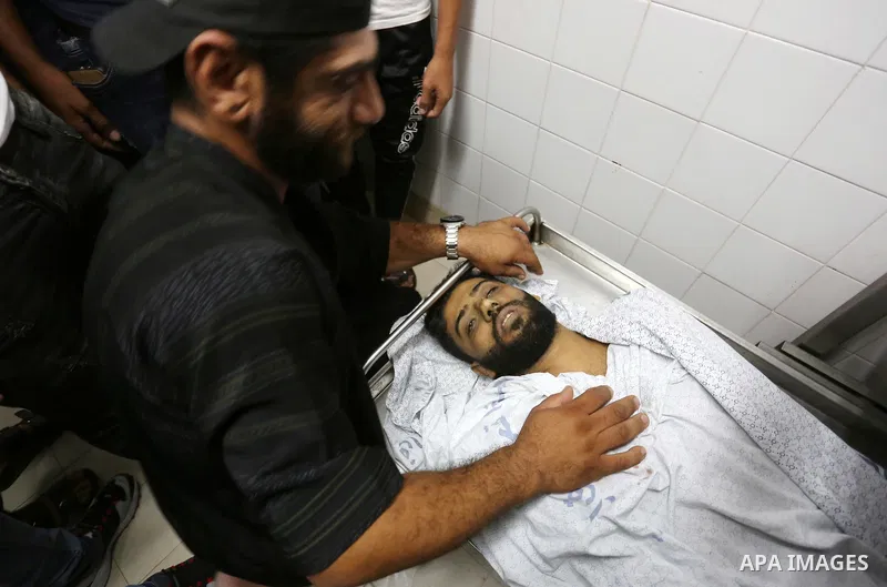 Relatives of Palestinian Hani Affana, 21, who was shot dead by Israeli troops during clashes in tents protest at the Israel-Gaza border, mourn next to his body at a morgue in a hospital, in Khan Younis in the southern Ga...