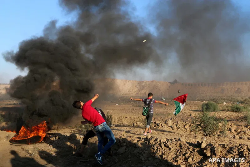 Palestinian protesters gather during clashes with Israeli troops in tents protest where Palestinians demand the right to return to their homeland at the Israel-Gaza border, in al-Bureij in the center of Gaza Strip on Sep...