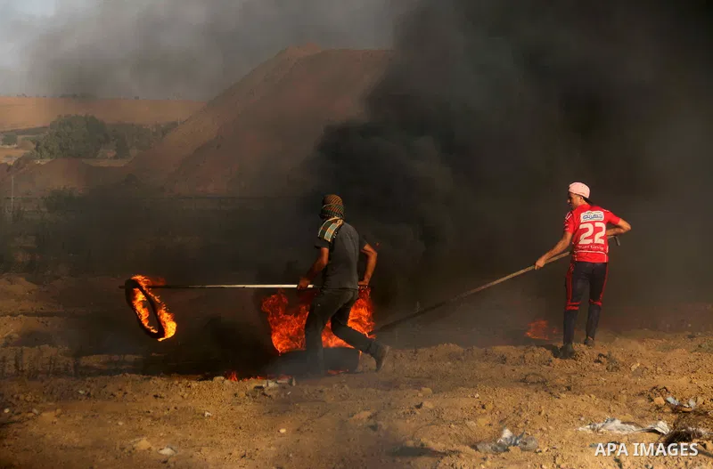 Palestinian protesters gather during clashes with Israeli troops in tents protest where Palestinians demand the right to return to their homeland at the Israel-Gaza border, in al-Bureij in the center of Gaza Strip on Sep...