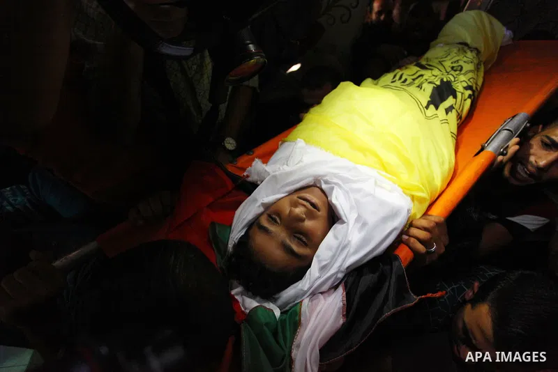 Mourners carry the body Palestinian boy Shady Abdel Aal, 11, who was shot dead by Israeli troops during clashes in tents protest at the Israel-Gaza border, during his funeral in Beit Lahia, in the northern of Gaza Strip...