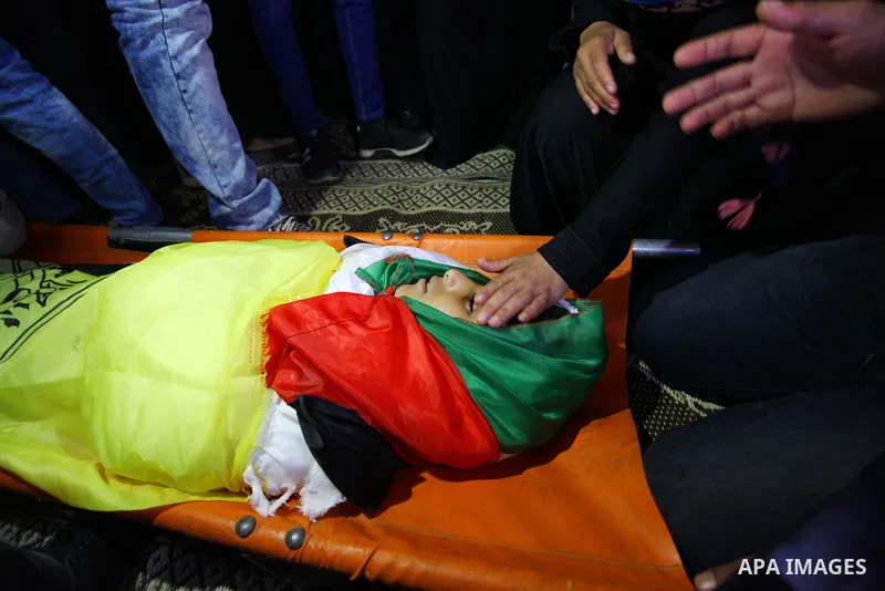 Relatives of Palestinian boy Shady Abdel Aal, 11, who was shot dead by Israeli troops during clashes in tents protest at the Israel-Gaza border, mourn next to his body during his funeral in Beit Lahia, in the northern of...