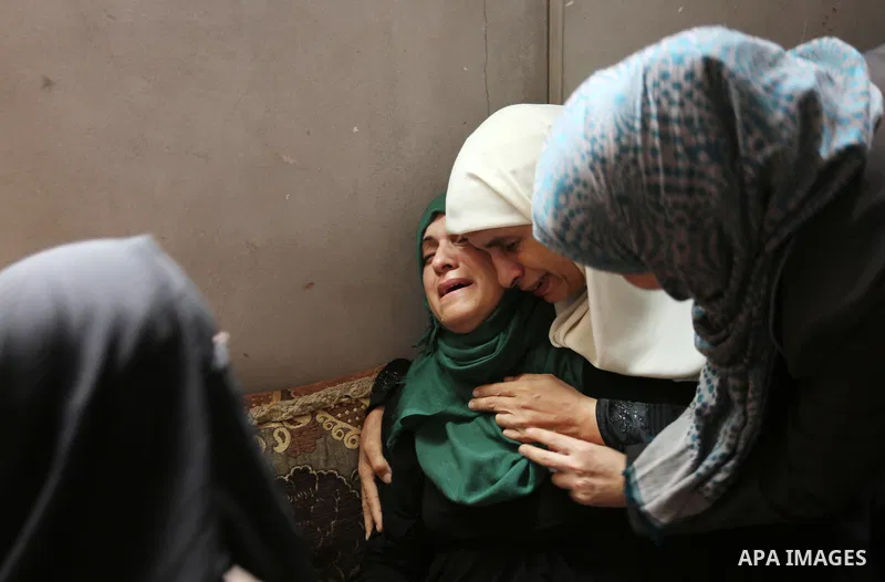 Relatives of Palestinian Mohammed Shaqoura, 21, who was shot dead by Israeli troops during clashes in tents protest at the Israel-Gaza border, mourn during his funeral in al-Maghazi in the center of Gaza Strip on Septemb...