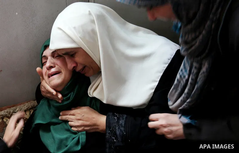 Relatives of Palestinian Mohammed Shaqoura, 21, who was shot dead by Israeli troops during clashes in tents protest at the Israel-Gaza border, mourn during his funeral in al-Maghazi in the center of Gaza Strip on Septemb...