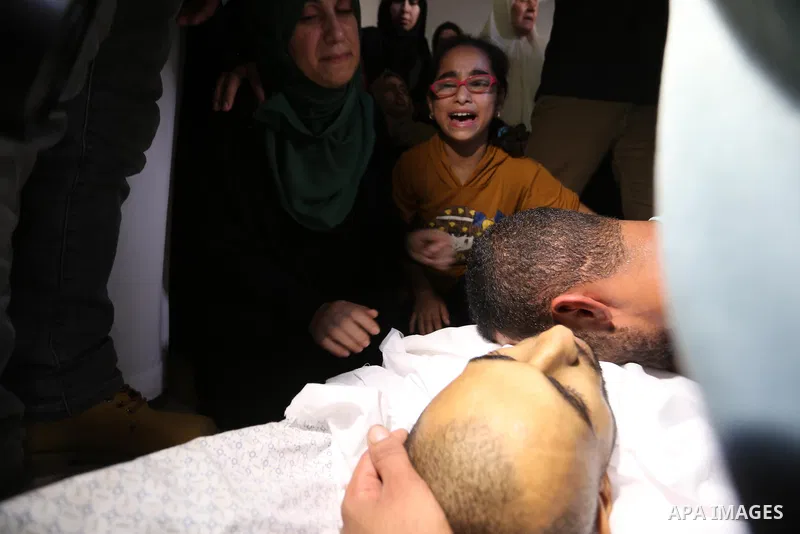 Relatives of Palestinian Mohammed Shaqoura, 21, who was shot dead by Israeli troops during clashes in tents protest at the Israel-Gaza border, mourn next to his body during his funeral in al-Maghazi in the center of Gaza...