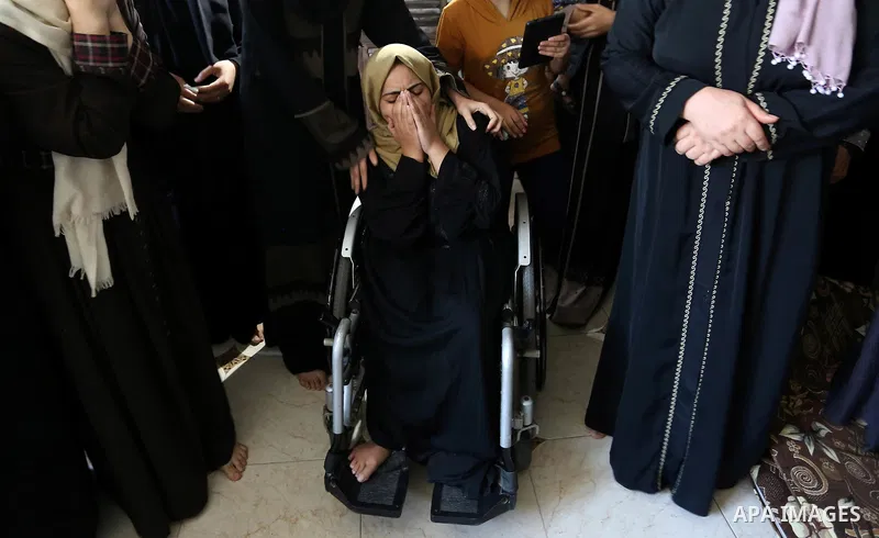 Relatives of Palestinian Mohammed Shaqoura, 21, who was shot dead by Israeli troops during clashes in tents protest at the Israel-Gaza border, mourn during his funeral in al-Maghazi in the center of Gaza Strip on Septemb...