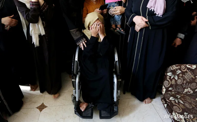Relatives of Palestinian Mohammed Shaqoura, 21, who was shot dead by Israeli troops during clashes in tents protest at the Israel-Gaza border, mourn during his funeral in al-Maghazi in the center of Gaza Strip on Septemb...