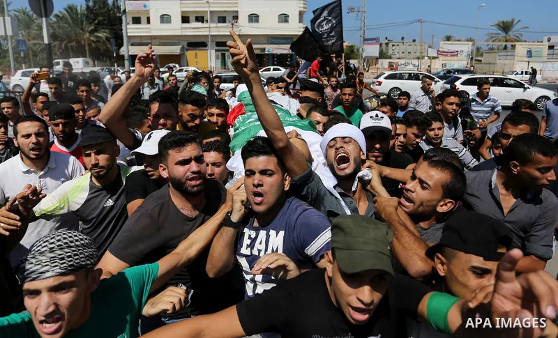 Mourners carry the body of Palestinian Mohammed Shaqoura, 21, who was shot dead by Israeli troops during clashes in tents protest at the Israel-Gaza border, during his funeral in al-Maghazi in the center of Gaza Strip on...