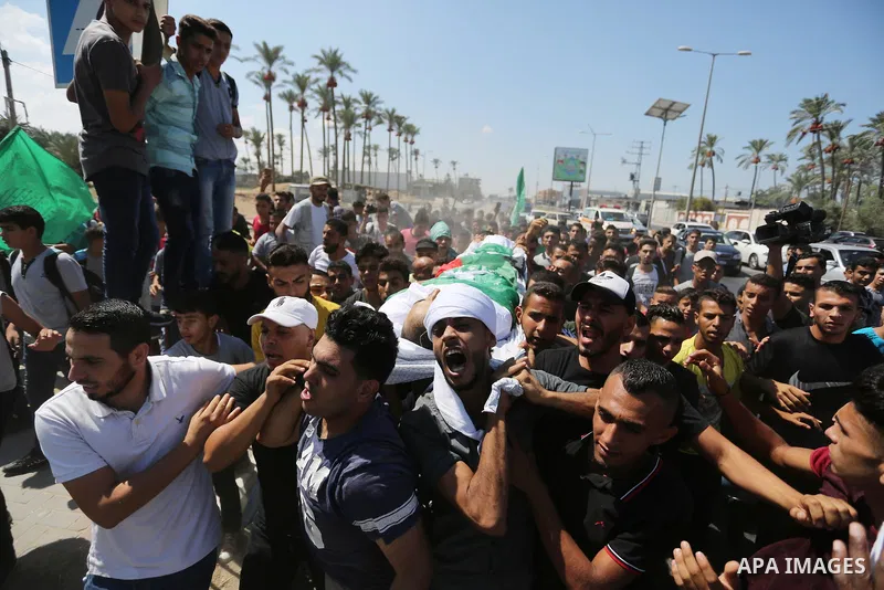 Mourners carry the body of Palestinian Mohammed Shaqoura, 21, who was shot dead by Israeli troops during clashes in tents protest at the Israel-Gaza border, during his funeral in al-Maghazi in the center of Gaza Strip on...