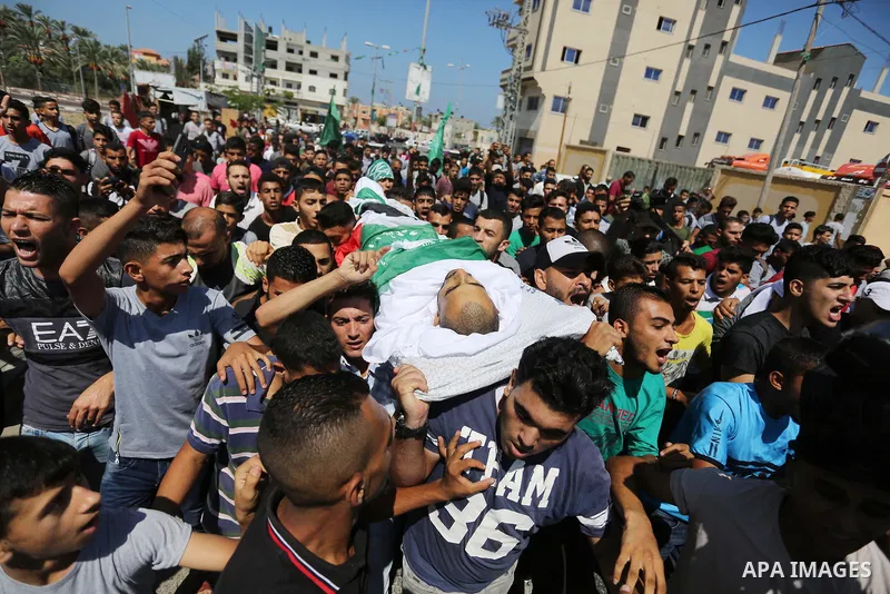 Mourners carry the body of Palestinian Mohammed Shaqoura, 21, who was shot dead by Israeli troops during clashes in tents protest at the Israel-Gaza border, during his funeral in al-Maghazi in the center of Gaza Strip on...