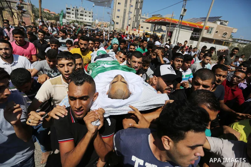 Mourners carry the body of Palestinian Mohammed Shaqoura, 21, who was shot dead by Israeli troops during clashes in tents protest at the Israel-Gaza border, during his funeral in al-Maghazi in the center of Gaza Strip on...