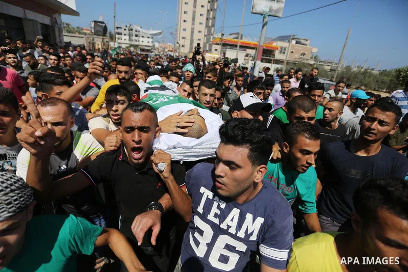 Mourners carry the body of Palestinian Mohammed Shaqoura, 21, who was shot dead by Israeli troops during clashes in tents protest at the Israel-Gaza border, during his funeral in al-Maghazi in the center of Gaza Strip on...
