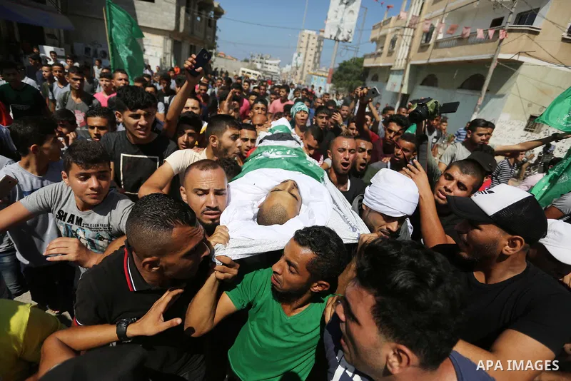Mourners carry the body of Palestinian Mohammed Shaqoura, 21, who was shot dead by Israeli troops during clashes in tents protest at the Israel-Gaza border, during his funeral in al-Maghazi in the center of Gaza Strip on...