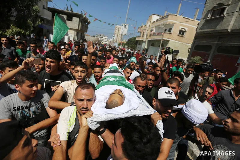 Mourners carry the body of Palestinian Mohammed Shaqoura, 21, who was shot dead by Israeli troops during clashes in tents protest at the Israel-Gaza border, during his funeral in al-Maghazi in the center of Gaza Strip on...