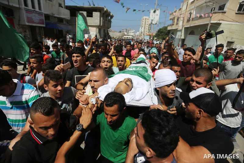 Mourners carry the body of Palestinian Mohammed Shaqoura, 21, who was shot dead by Israeli troops during clashes in tents protest at the Israel-Gaza border, during his funeral in al-Maghazi in the center of Gaza Strip on...