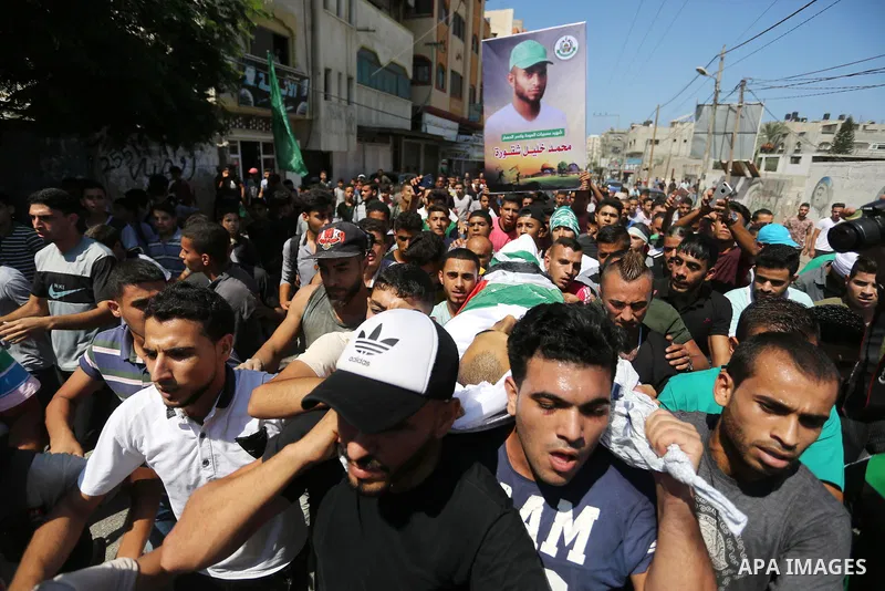 Mourners carry the body of Palestinian Mohammed Shaqoura, 21, who was shot dead by Israeli troops during clashes in tents protest at the Israel-Gaza border, during his funeral in al-Maghazi in the center of Gaza Strip on...